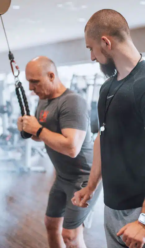 David Bachmeier, professioneller Fitness-Trainer, bietet effektive Beratung zum Thema Muskelaufbau am Trainingsgerät im Fitnessstudio.